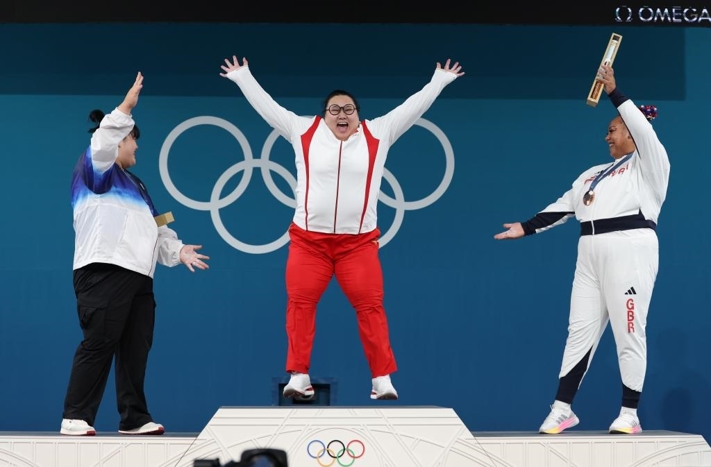 中國選手李雯雯（中）在巴黎奧運會舉重女子81公斤以上級頒獎儀式中登上領獎臺（2024年8月11日攝）。新華社記者 楊磊 攝