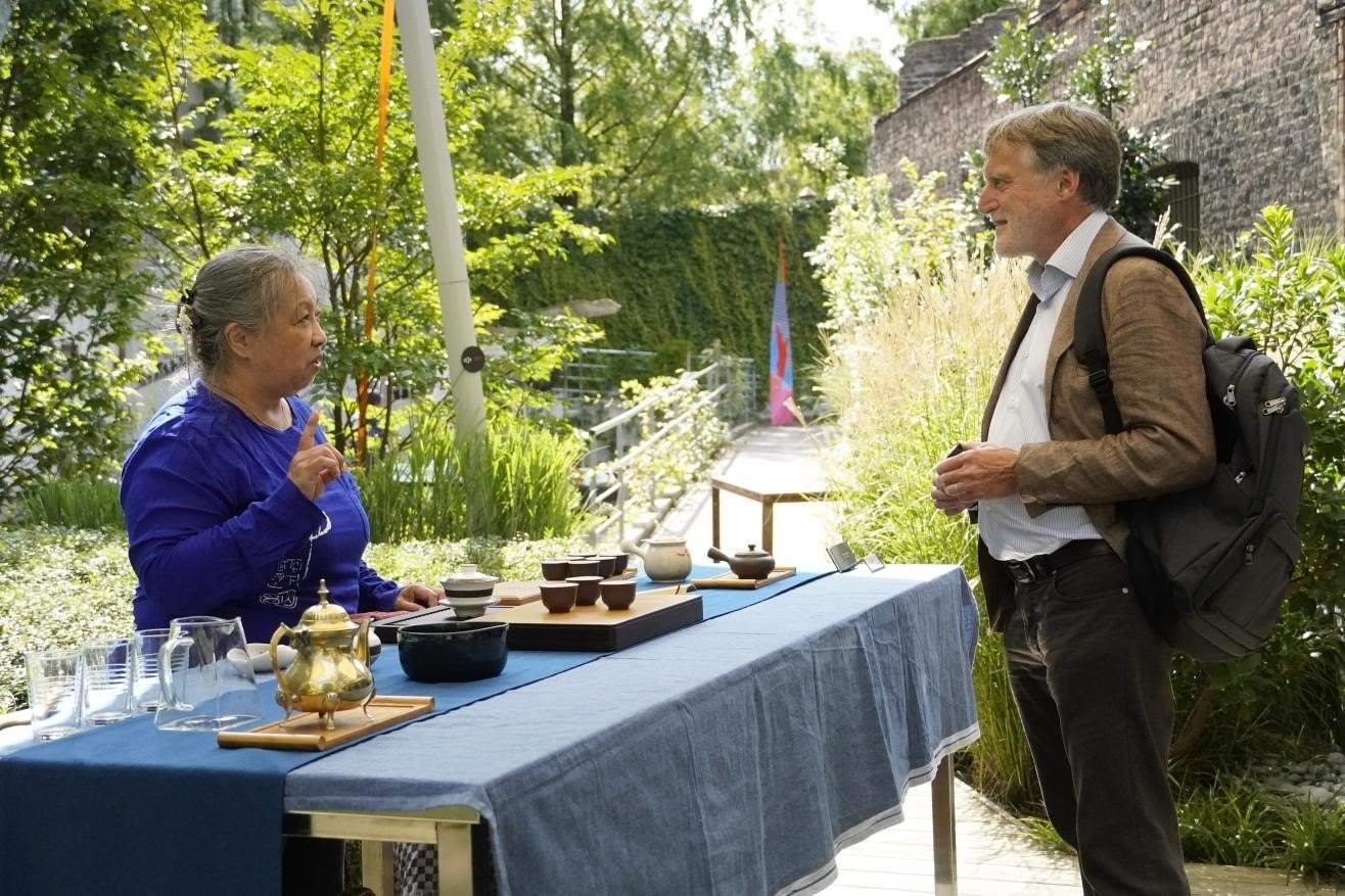 在博物館的戶外花園來賓品味中國茶藝。比利時維他命文化傳媒供圖