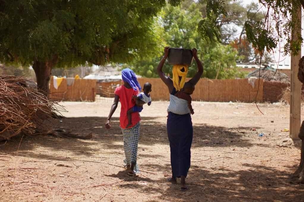 2023年3月20日，在塞內(nèi)加爾久爾貝勒區(qū)的泰內(nèi)富勒村，村民將取到的水運(yùn)回家。新華社記者 王子正 攝