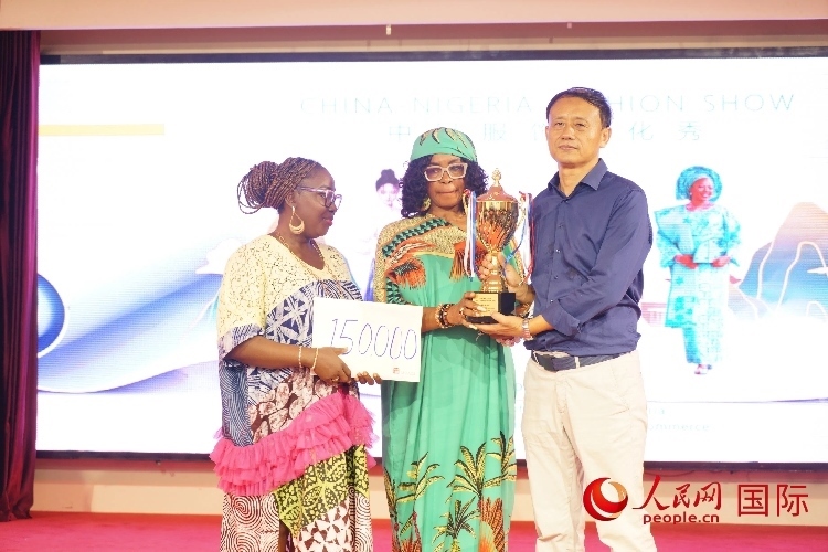 中國駐尼日利亞使館文化參贊兼中國文化中心主任李旭大（右）為最佳表現(xiàn)獎頒獎（中）。人民網記者 姜宣攝