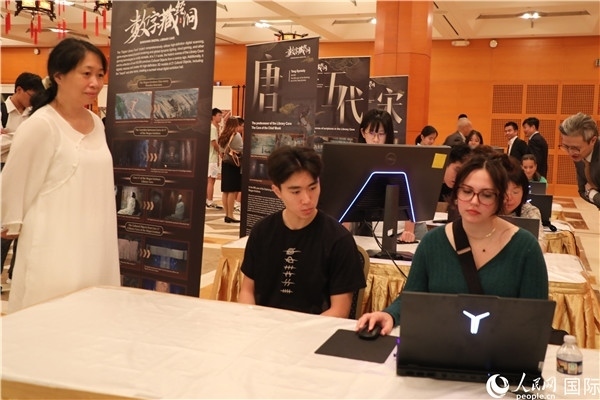 在活動現(xiàn)場，當(dāng)?shù)孛癖婓w驗(yàn)“數(shù)字藏經(jīng)洞”云游戲，沉浸式體驗(yàn)敦煌文化。 人民網(wǎng)記者 李志偉攝