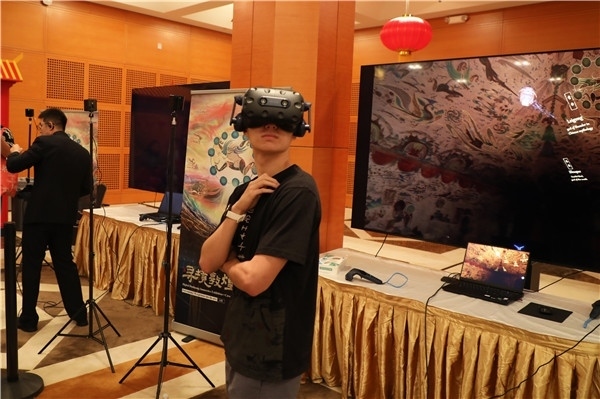 1、在本次活動的展覽現(xiàn)場，敦煌研究院與騰訊展示了“數(shù)字藏經(jīng)洞”和“尋境敦煌”等創(chuàng)新互動產(chǎn)品。圖為當(dāng)?shù)孛癖娡ㄟ^VR虛擬游覽洞窟。 人民網(wǎng)記者 李志偉攝