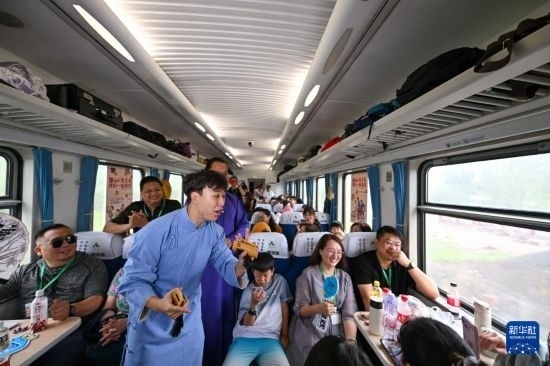 9月7日，相聲演員在S910列車上為旅客表演快板。