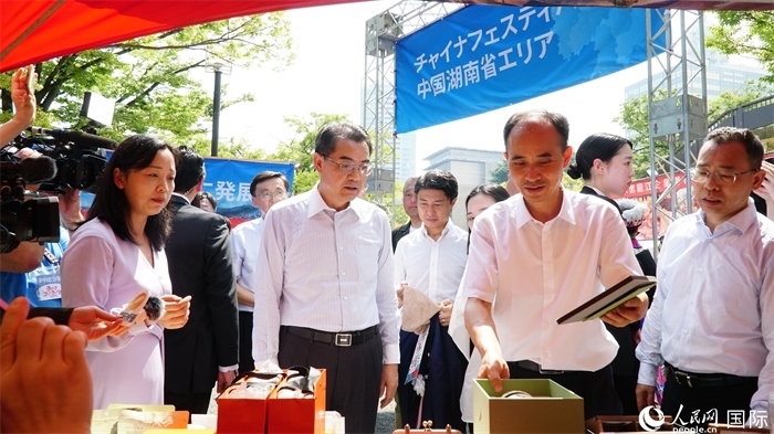 湖南展位工作人員向中國(guó)駐日本大使吳江浩介紹特色文創(chuàng)產(chǎn)品。人民網(wǎng) 蔣曉辰攝