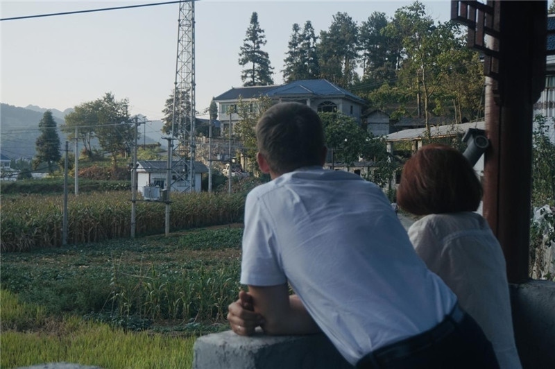 望得見山，看得見水，記得住鄉(xiāng)愁。每個人心中都有一個屬于自己的“花茂村”，在這方心田，走遍千山萬水，鄉(xiāng)音未改鬢毛衰。吉爾吉斯斯坦《比什凱克晚報》第一副總編輯妮娜·尼奇博洛娃與《中國與俄羅斯》雜志社社長奧列格·別列日內(nèi)赫攝在花茂村民居屋檐下并肩佇立，眺望山水，尋覓鄉(xiāng)愁。（李光裕攝）