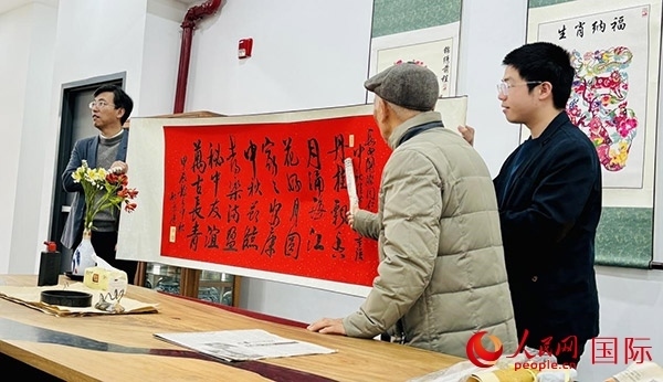 旅秘書法家向現(xiàn)場(chǎng)觀眾展示書法作品。人民網(wǎng)記者 宋亦然攝