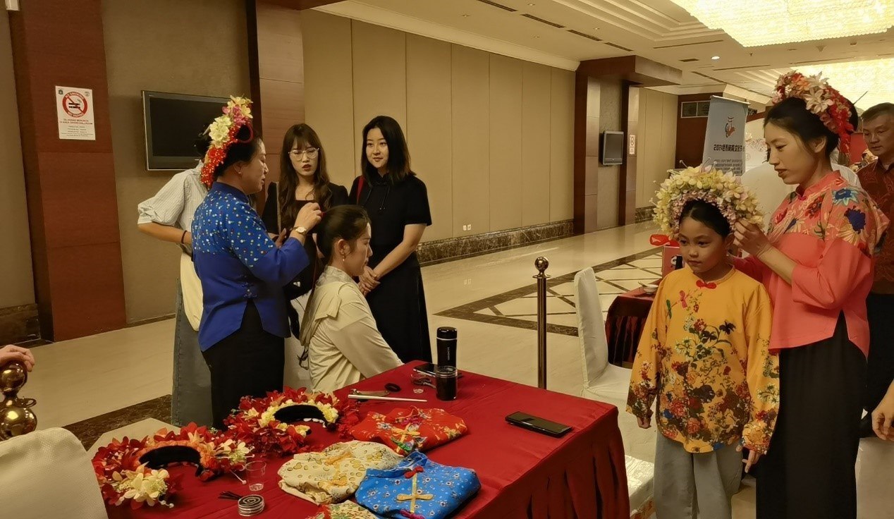 阿拉扎大學(xué)孔子學(xué)院志愿者老師向傳承人學(xué)習(xí)簪花圍。阿拉扎大學(xué)孔子學(xué)院供圖