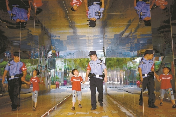 ?7月16日，重慶市公安局江北區(qū)分局一名民警在巡邏途中遇到一個(gè)獨(dú)自玩耍的小男孩，民警將其送回家。王洪平攝