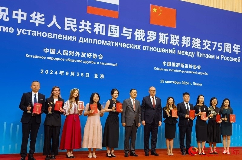 楊萬(wàn)明會(huì)長(zhǎng)和莫爾古洛夫大使為10位中俄青年友好微視頻創(chuàng)意大賽獲獎(jiǎng)代表頒獎(jiǎng)。人民網(wǎng)記者 李明琪攝