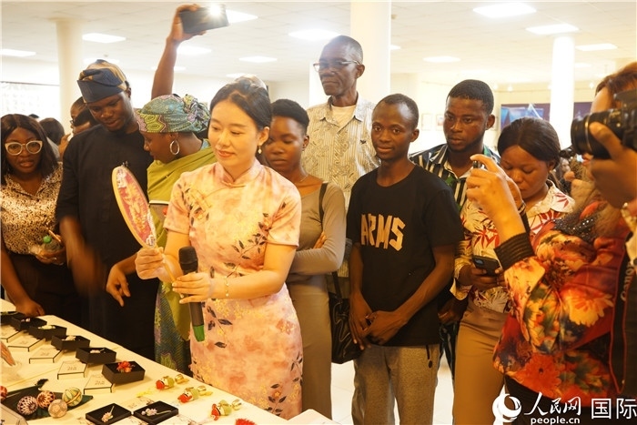 向尼日利亞觀眾介紹中國(guó)刺繡。人民網(wǎng)記者 姜宣攝