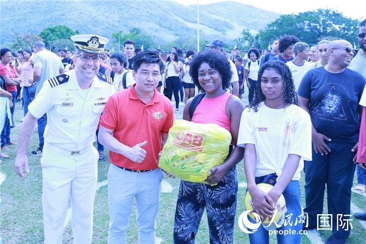 巴西中國浙江商會會長鄭俠茂向巴西貧困社區(qū)兒童及家庭捐贈基礎食品籃子和足球。人民網(wǎng)記者陳海琪 攝