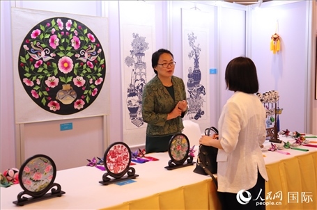 青海非遺文化傳承人向嘉賓介紹展品。人民網(wǎng)實習(xí)生姚欣可攝