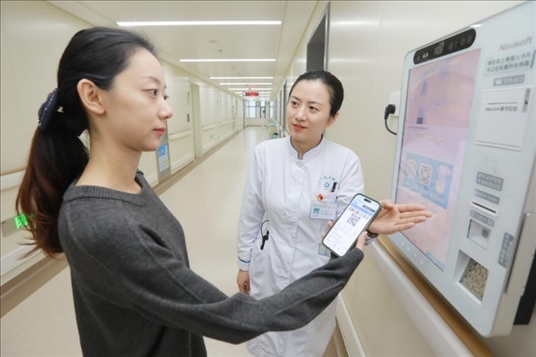 醫(yī)護(hù)人員引導(dǎo)患者在自助機(jī)前辦理自助入院手續(xù)。圖片來(lái)源：山東第一醫(yī)科大學(xué)第二附屬醫(yī)院