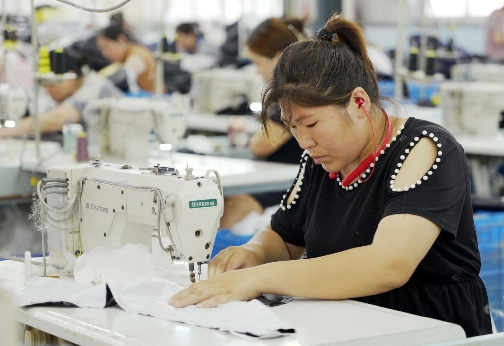 5月20日，村民在李寨村服裝加工廠內(nèi)忙碌。河南省周口市沈丘縣馮營鎮(zhèn)李寨村地處豫東平原。近年來，乘著脫貧攻堅(jiān)與鄉(xiāng)村振興政策的東風(fēng)，李寨村積極探索產(chǎn)業(yè)發(fā)展模式，通過“龍頭企業(yè)+村集體經(jīng)濟(jì)+農(nóng)戶”的方式，逐漸發(fā)展形成肉牛養(yǎng)殖、設(shè)施農(nóng)業(yè)、服裝加工、康養(yǎng)民宿等產(chǎn)業(yè)，以產(chǎn)業(yè)振興助力鄉(xiāng)村振興。新華社記者 李嘉南 攝