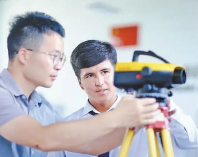 在塔吉克斯坦首都杜尚別的魯班工坊，來自天津城市建設(shè)管理職業(yè)技術(shù)學(xué)院的老師（左）為當(dāng)?shù)貙W(xué)生提供指導(dǎo)。新華社記者 鄭開君 攝