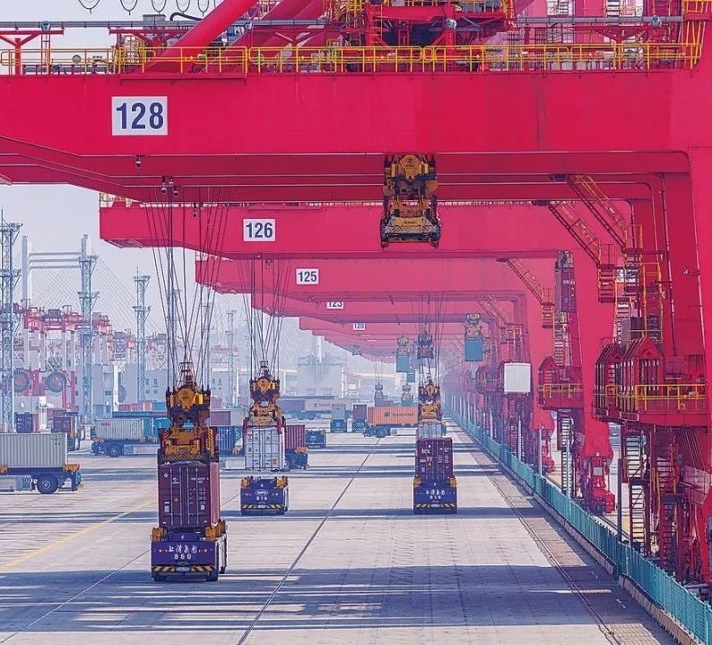 共建“一帶一路”國家在工作制度對接、技術(shù)標(biāo)準(zhǔn)協(xié)調(diào)、檢驗結(jié)果互認(rèn)等方面強化合作、統(tǒng)一標(biāo)準(zhǔn)，貿(mào)易自由化便利化水平不斷提升。上海洋山港海關(guān)對接共建國家進出口貨物相關(guān)標(biāo)準(zhǔn)，推動通關(guān)一體化方式申報，提升通關(guān)效率。圖為無人駕駛的全自動導(dǎo)引車在洋山港穿梭往來，搬運集裝箱。王初 攝