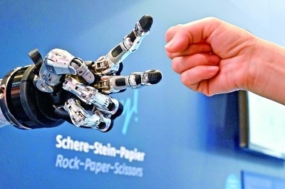 在德國漢諾威工博會(huì)上，參觀者與一款智能機(jī)器人進(jìn)行“石頭剪子布”游戲。新華社發(fā)