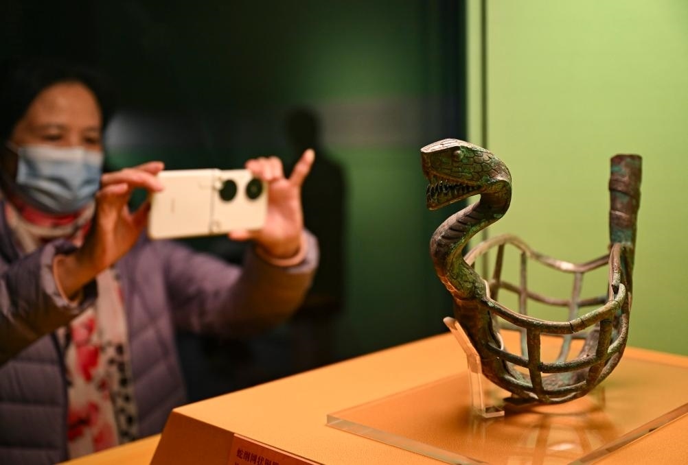 1月14日，觀眾在上海博物館蛇年迎春展拍攝展品蛇綱網(wǎng)狀銅器。新華社發(fā)（陳浩明攝）