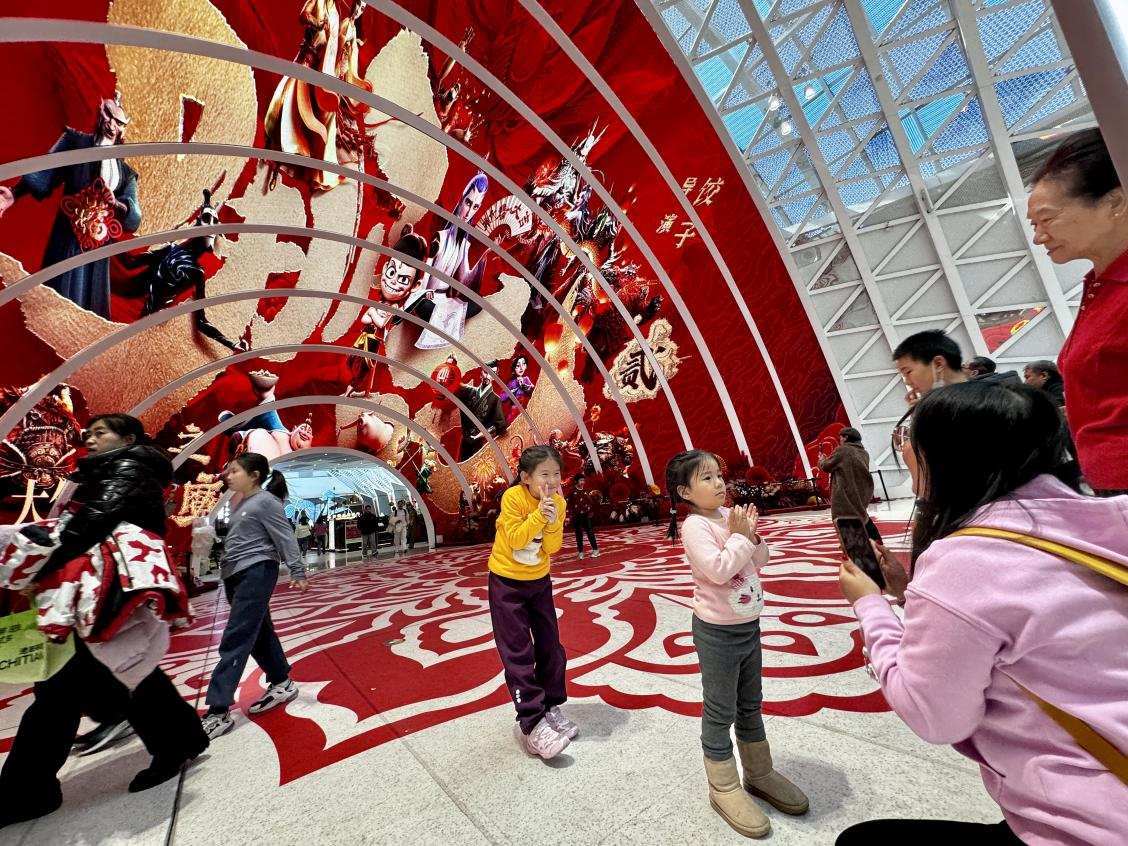 乙巳蛇年春節(jié)期間，影迷在《哪吒之魔童鬧?！肪薹?bào)前拍照打卡。