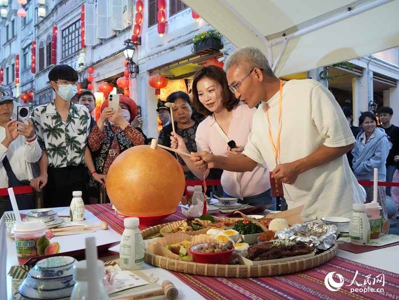 嘉賓品嘗海南傳統(tǒng)美食“煎堆”。人民網(wǎng)記者 張力洋攝
