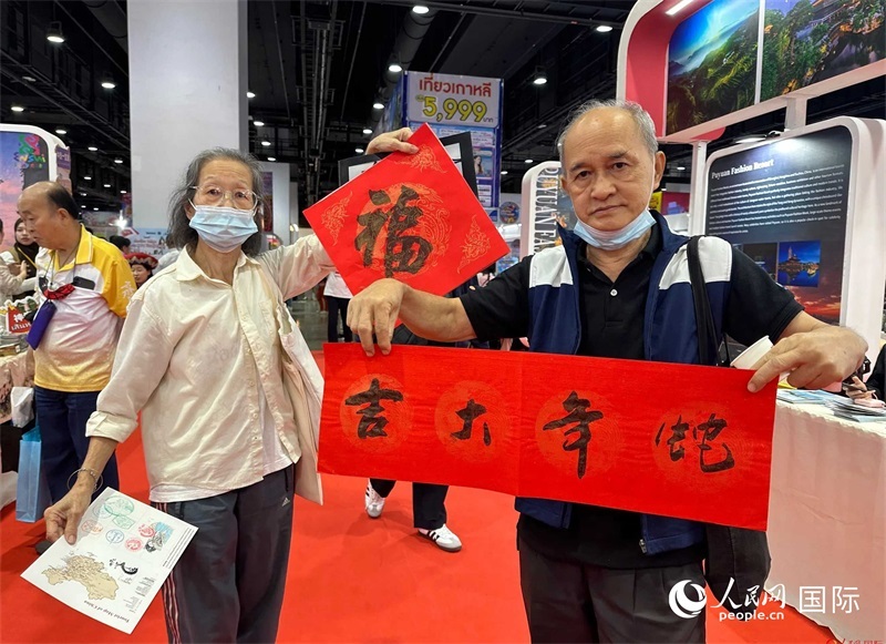 2025蛇年春節(jié)，泰國(guó)市民展示他們領(lǐng)到的華人手寫春聯(lián)。人民網(wǎng)記者 簡(jiǎn)承淵攝