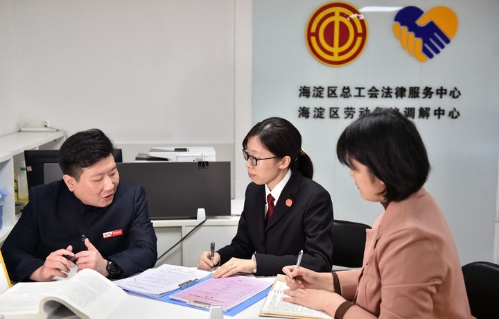 2025年3月6日，在北京市海淀區(qū)總工會(huì)勞動(dòng)爭(zhēng)議調(diào)解中心，海淀區(qū)人民法院法官王琰（中）與該中心工作人員就糾紛化解情況進(jìn)行溝通。新華社記者 趙婷婷 攝