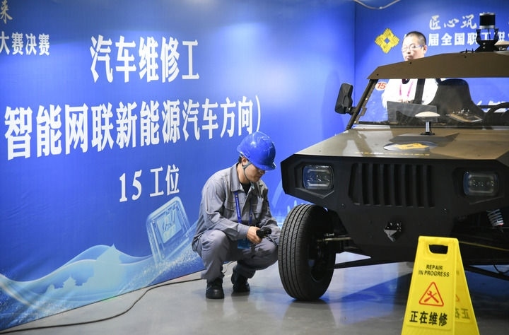 2024年9月11日，由全國(guó)總工會(huì)、人力資源和社會(huì)保障部等單位主辦的第八屆全國(guó)職工職業(yè)技能大賽決賽在陜西開(kāi)幕。這是選手在位于西安國(guó)際會(huì)展中心的比賽場(chǎng)地參加汽車維修工（智能網(wǎng)聯(lián)新能源汽車方向）工種比賽。新華社記者 張博文 攝