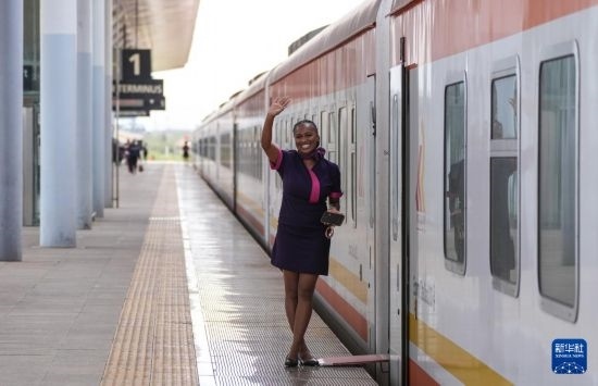 5月31日，在蒙內鐵路內羅畢站，一名乘務員在即將開往蒙巴薩的E2次列車旁等候乘客。新華社記者 李亞輝 攝