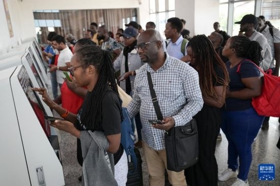 5月31日，在蒙內鐵路內羅畢站，乘客在自助取票機前排隊取票。新華社記者 楊光 攝