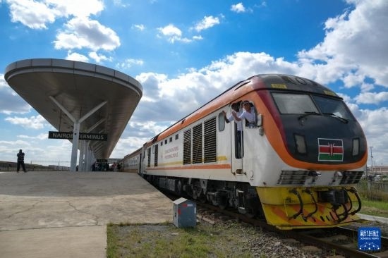 5月31日，在蒙內鐵路內羅畢站，機車駕駛員蔣立平（右）和博爾在即將開往蒙巴薩的E2次列車上揮手致意。新華社記者 楊光 攝