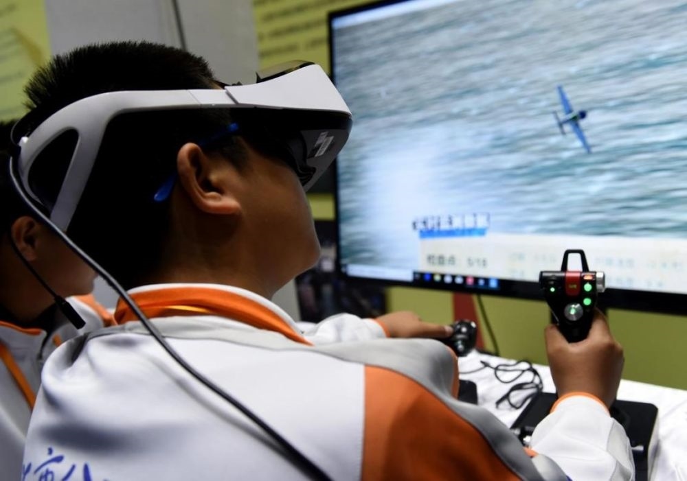 北京市八一學(xué)校的學(xué)生在北京市中小學(xué)生特色科技活動(dòng)展示上體驗(yàn)VR技術(shù)（2018年11月24日攝）新華社記者 羅曉光 攝。